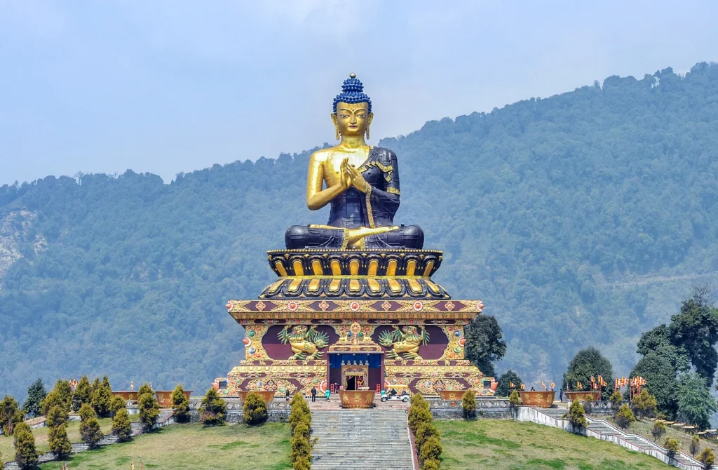 The majestic Buddha statue at Ravangla Buddha Park surrounded by manicured gardens, prayer flags, and Himalayan landscapes, showcasing one of the best Places to Visit in Sikkim for nature and spirituality seekers.