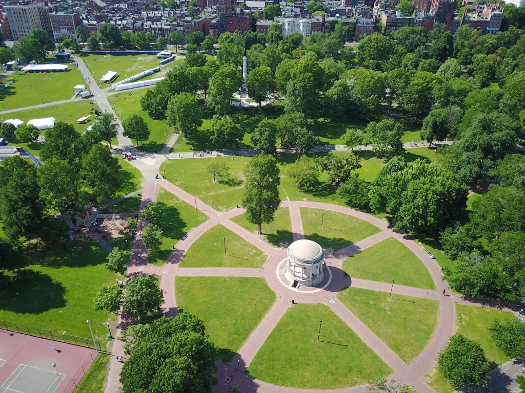 Things to Do in Boston: Visitors relaxing at Boston Common and the Public Garden with scenic paths, flowers, and skyline.