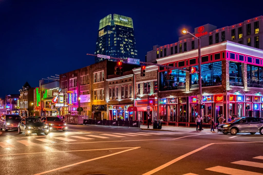Things to Do in Nashville: Visitors enjoying live music on Broadway with neon lights, historic venues, and downtown Nashville.